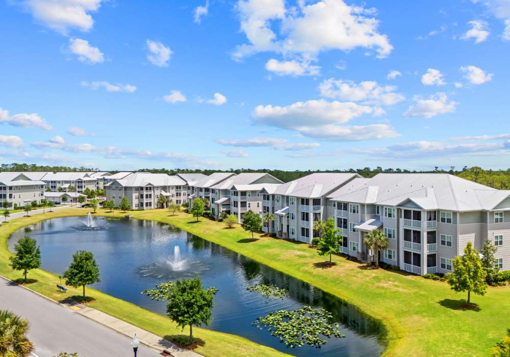 Apartment building and pond with fountains at Pier Park Crossings