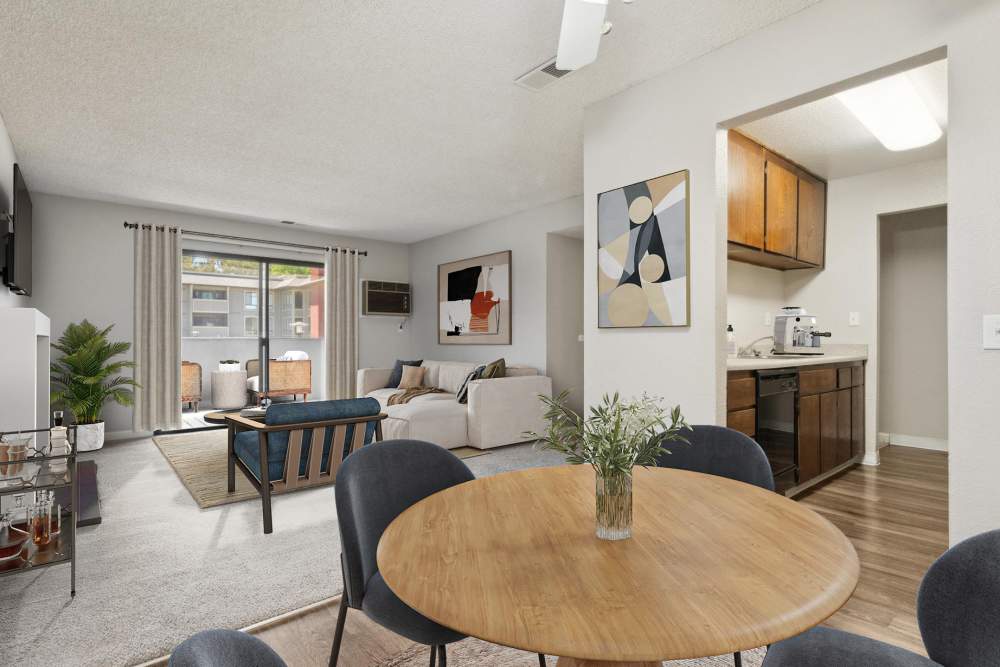 Kitchen with brown cabinets, dining area and living room with sliding door to a patio at Muirwood Apartment Homes in Martinez, California