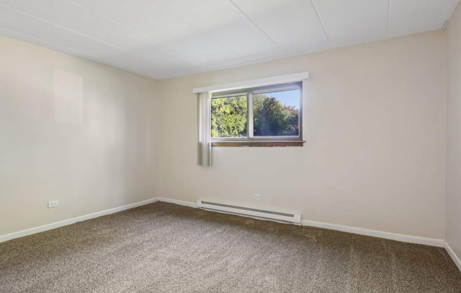 Bedroom with window at Regents Park Apartments in Bensenville, Illinois