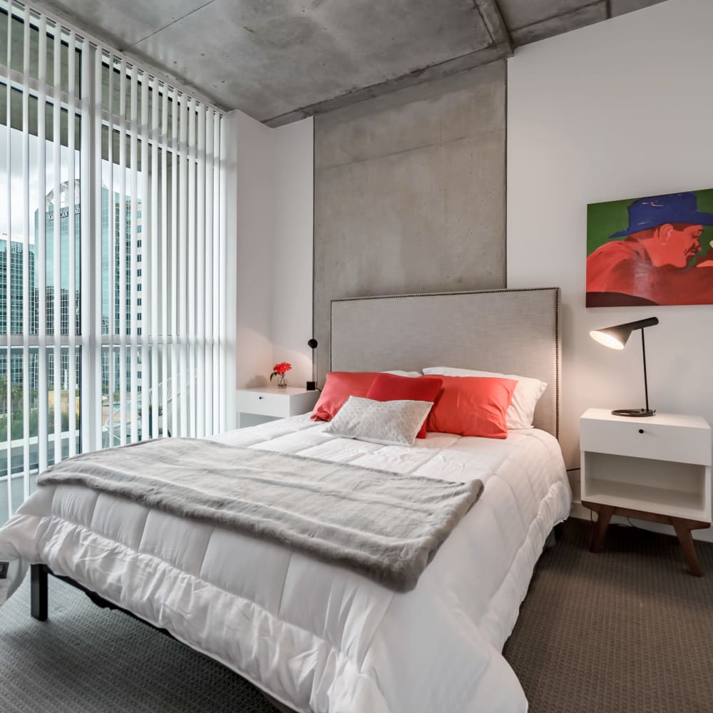 Well-decorated model home's primary bedroom with floor-to-ceiling windows and amazing city views at CitiTower in Orlando, Florida