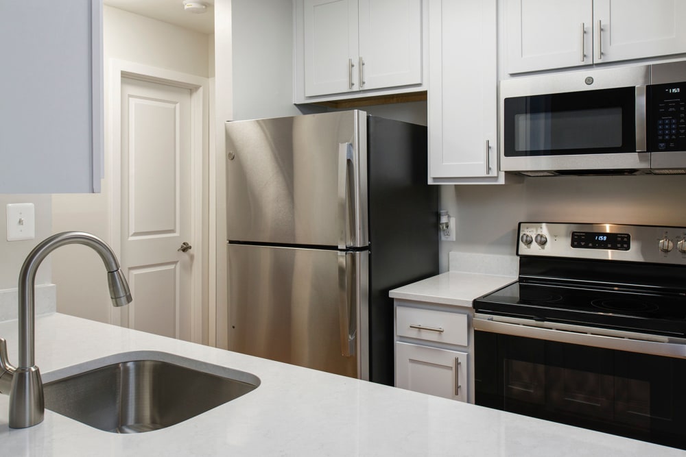Wood flooring and white countertops in an apartment kitchen at Stonecreek Club in Germantown, Maryland