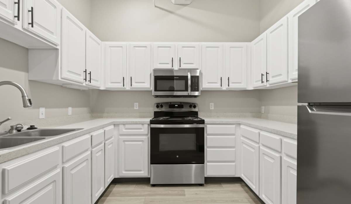 Kitchen with white cabinets, hardwood flooring and dishwasher at The Globe in Grand Rapids, Michigan 