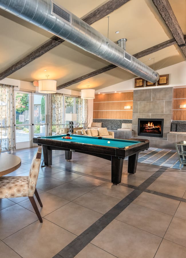 Resident clubhouse with a billiards table and a fireplace at Azure Apartment Homes in Petaluma, California
