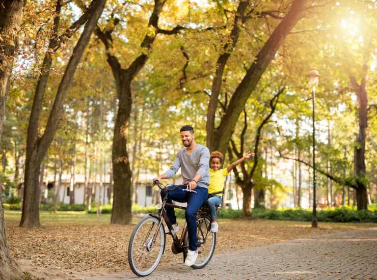 Resident going around on a bicycle with his son at Avalon in Davis, California