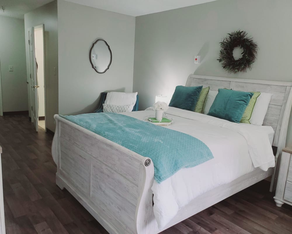 A furnished bedroom with wood flooring at Concord Place in Concord, North Carolina