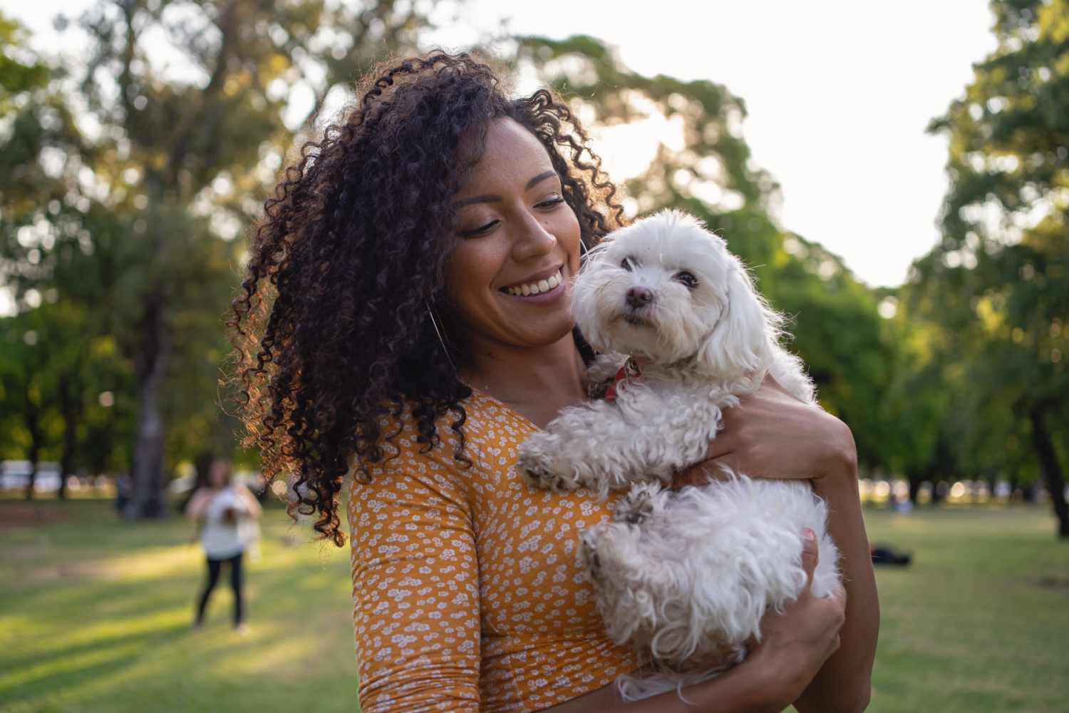 Resident holding her dog in a park near Steeple Chase Apartments in Peoria, Arizona