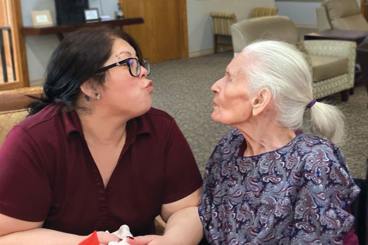 A resident and a caregiver having a nice conversation at Oxford Glen Memory Care at Grand Prairie in Grand Prairie, Texas 