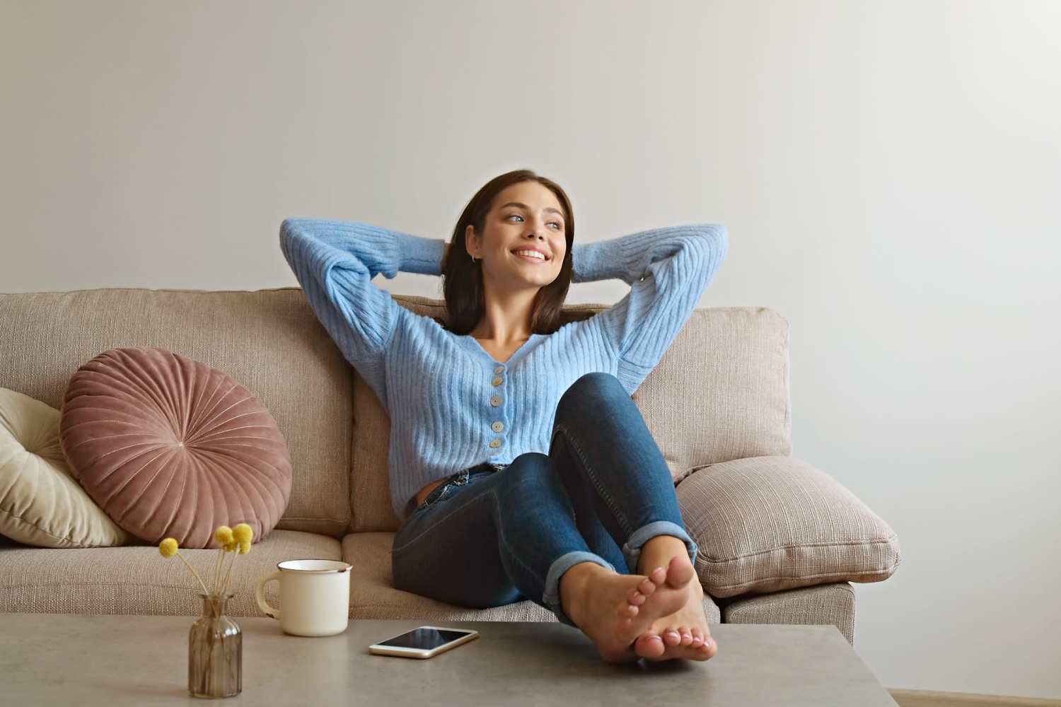 Resident lwoman relaxing on her couch in her apartment at Tribecca Pointe Apartments in Hurst, Texas