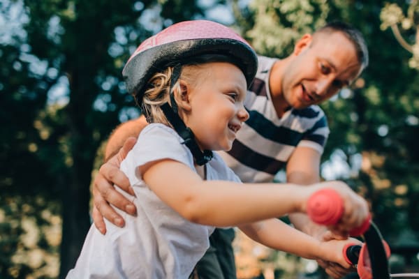 A resident pushing his child on a bike at Forest Edge Townhomes in Raleigh, North Carolina