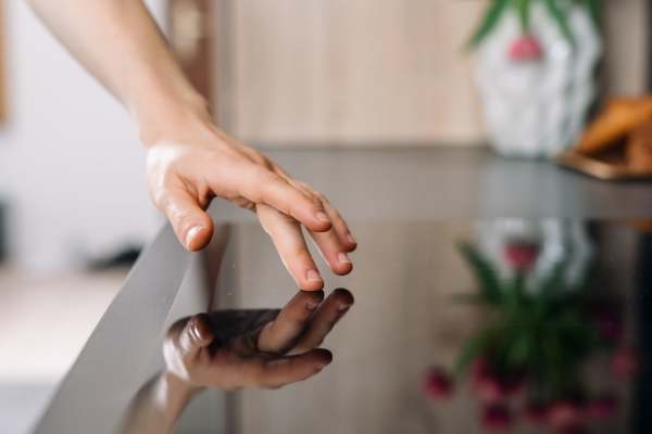 Hand touching a sleek modern countertop surface at Eagle Ridge Circle in Rochester, New York