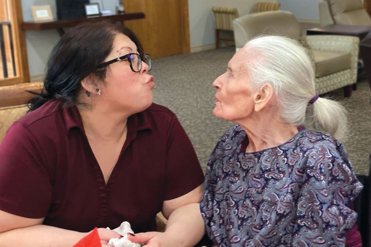 A resident and a caregiver having a nice conversation at Oxford Glen Memory Care at Carrollton in Carrollton, Texas 