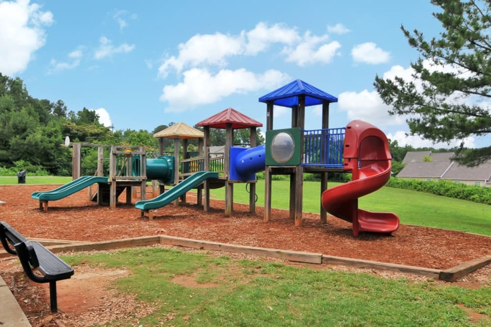Children's playground surrounded by grass to run around on at Cherokee Summit Apartments in Acworth, Georgia