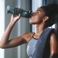 A woman drinking water in the fitness center at EOS in Orlando, Florida