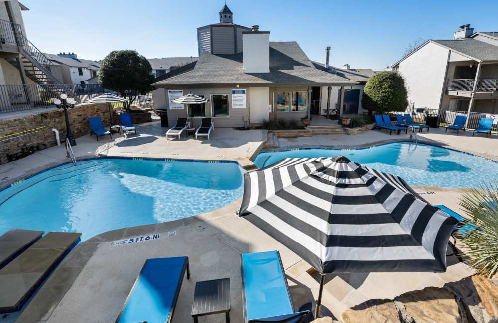 Community pool with multiple sun loungers at 18Eleven Frankford in Carrollton,Texas