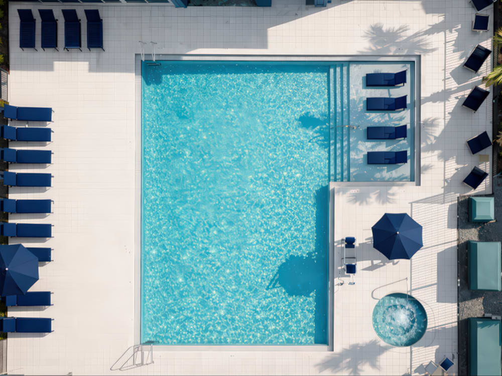 Swimming pool with lounge chairs and umbrellas at Viva At Palm Coast in Palm Coast, Florida 