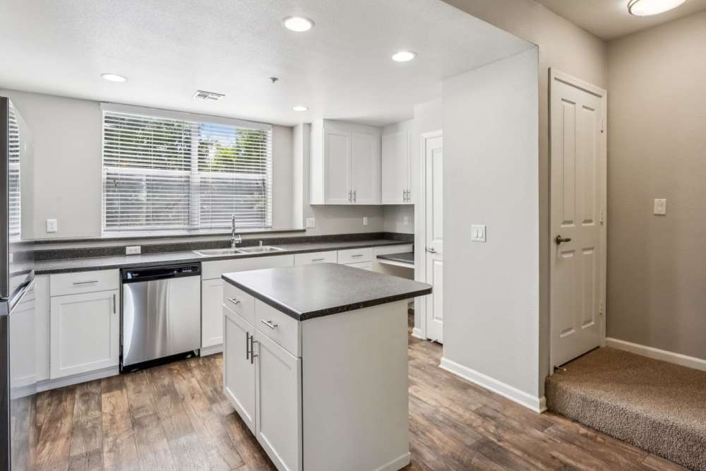 Kitchen with island near stairs leading to a second floor at Azure Apartment Homes in Petaluma, California