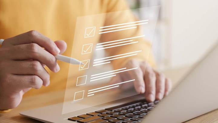 Stylus completing digital checklist on laptop at {{location_name}} in {{location_city}}, {{location_state_name}}