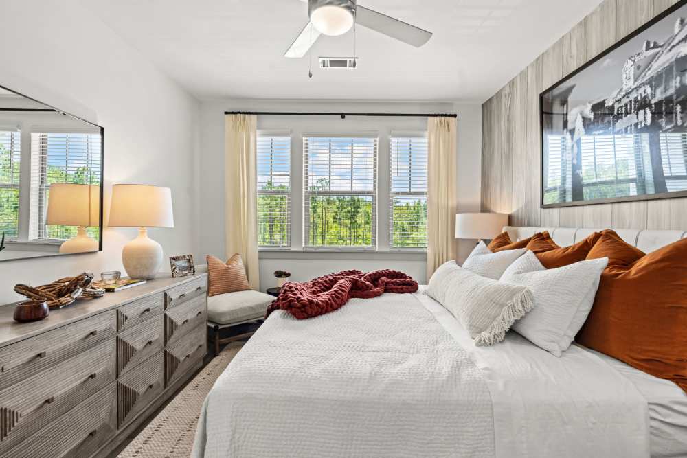 Bedroom with comfortable bed, ceiling fan and wood style floor at Watersound Origins Crossings in Inlet Beach, Florida