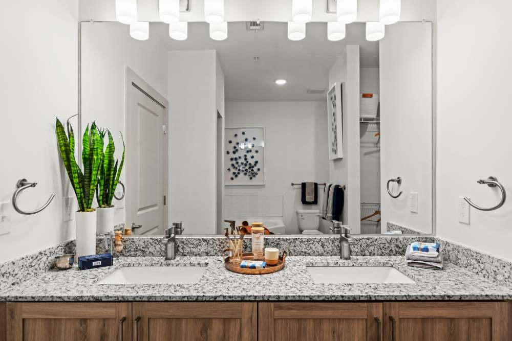 Bright bathroom with two sinks and wood cabinet at Watersound Origins Crossings in Inlet Beach, Florida