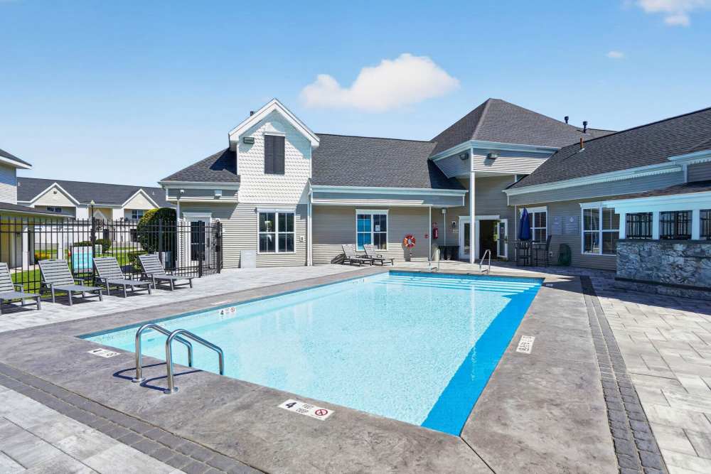 Community swimming pool with sun loungers at Mansions at Delmar, an Eagle Rock Community in Delmar, New York