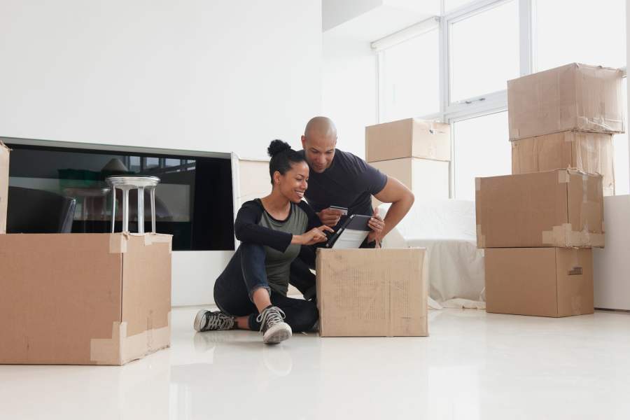 A man and woman sit on the floor , surrounded by unpacked boxes  at Mountainside Storage in Sultan, Washington