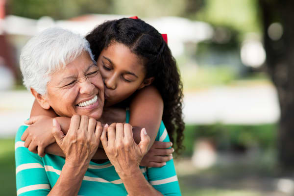 A young girl gives her grandma a kiss at Ramsey Village Continuing Care in Des Moines, Iowa