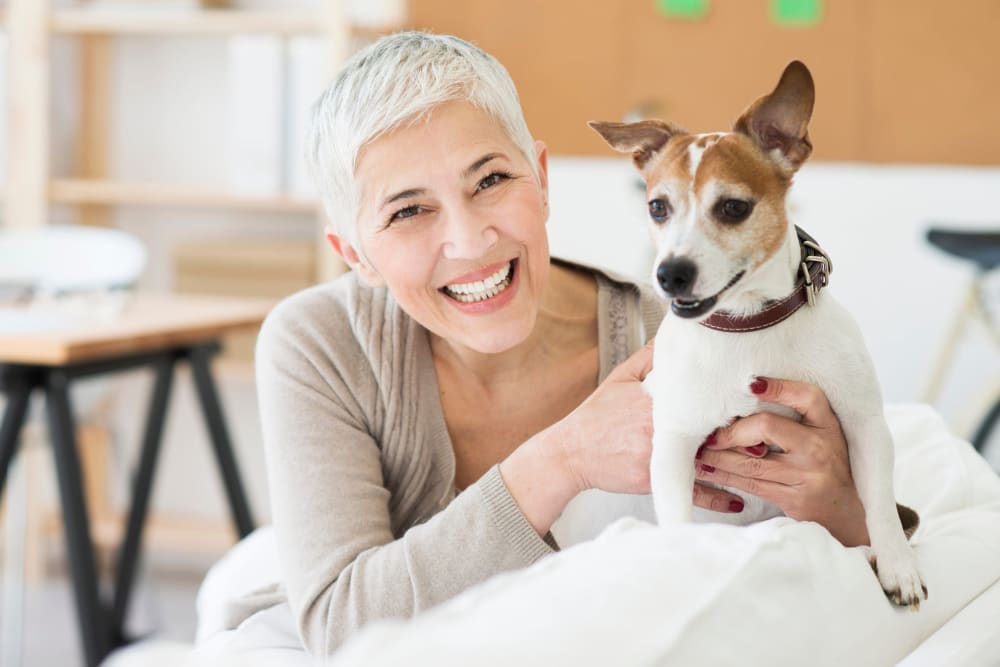 Resident smiling with dog at Atlas Point at Prestonwood in Carrollton, Texas.