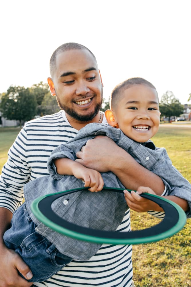Father and son playing in a park near their home at Tory Estates Apartment Homes in Clementon, New Jersey