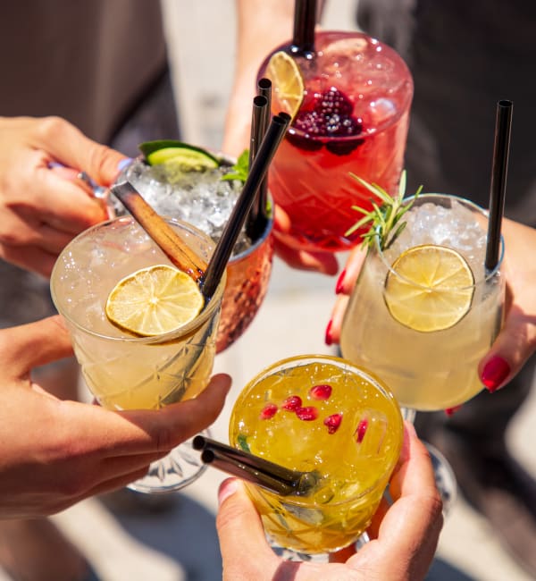 A group of people holding drinks together near Ravella at Town Center in Jacksonville, Florida