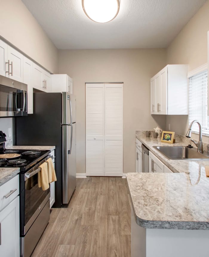 Kitchen with hardwood floors and stainless appliances in model home at IMT Pinebrook Pointe in Margate, FL