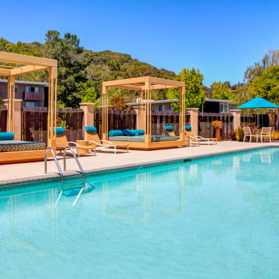 Cabanas and chaise lounge chairs around the pool at Sofi Belmont Hills in Belmont, California
