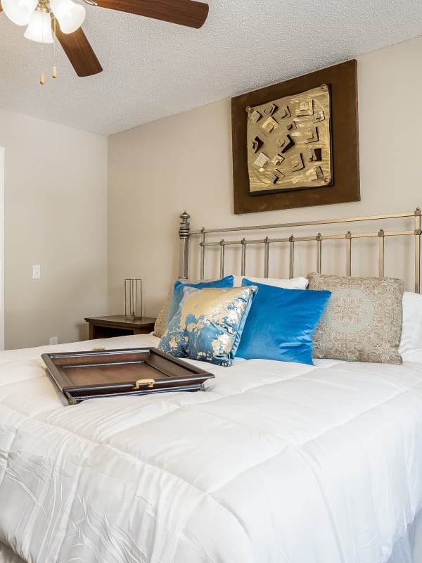 Model master bedroom with plush carpeting and an accent wall at Tuscany Pointe at Somerset Place Apartment Homes in Boca Raton, Florida