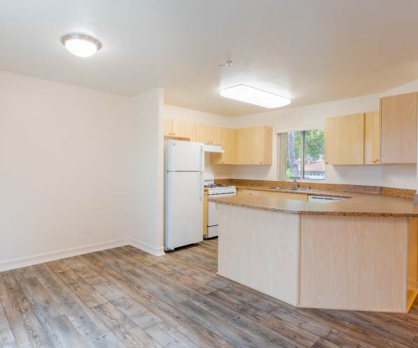 Inside a home with wood floors and an open kitchen at Vista Ridge in Vista, California