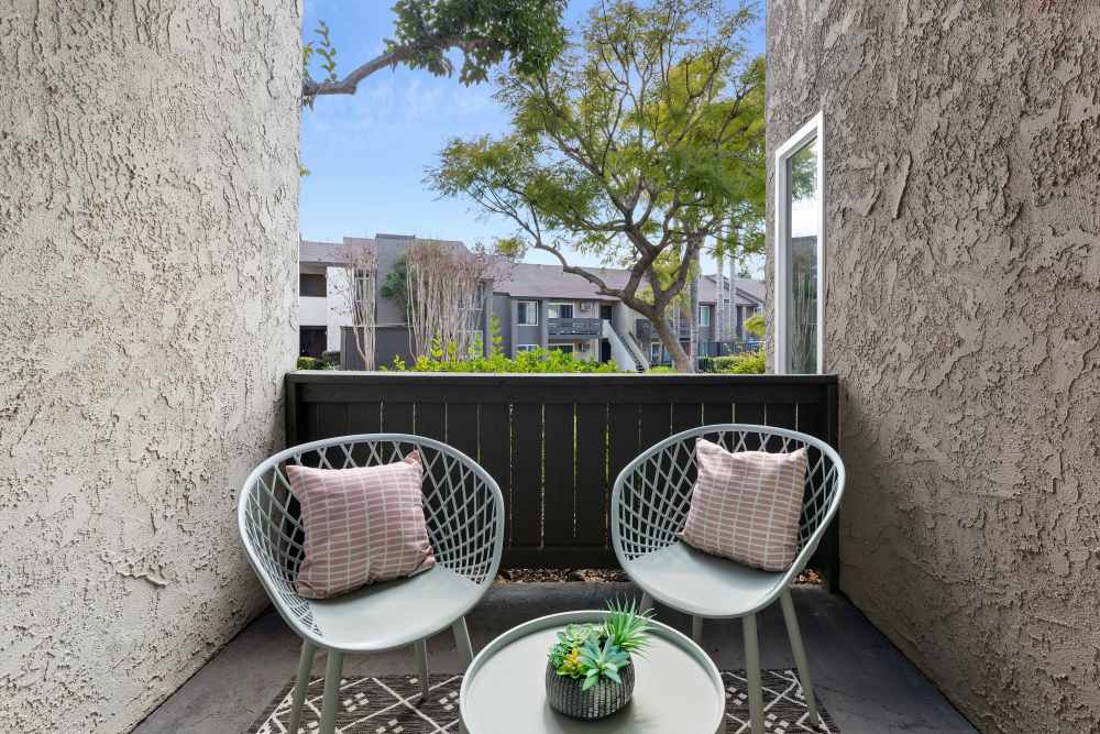 Cozy balcony with seating and a view of greenery at Sofi Laguna Hills in Laguna Hills, California