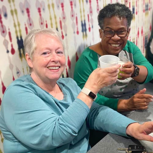 Residents and team member eating watermelon at Oxford Villa Active Senior Apartments in Wichita, Kansas