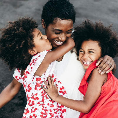 Happy mother and daughters sharing a hug at The Reserve at Patterson Place in Durham, North Carolina