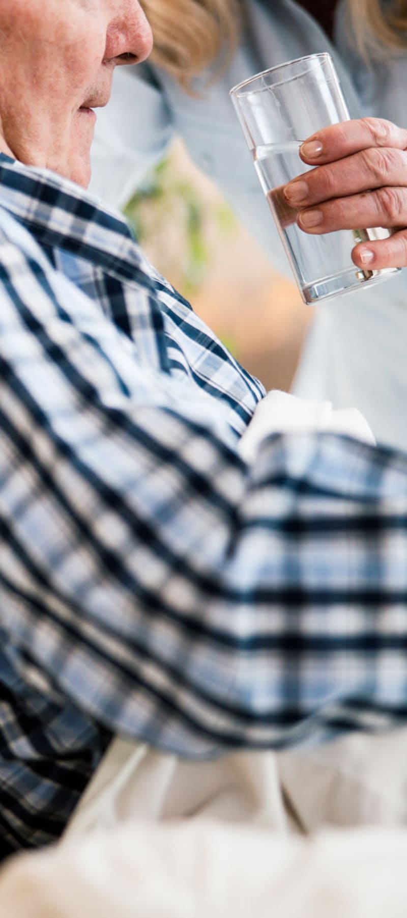 Resident getting assistance with drinking water at Transitions At Home - Central in Stevens Point, Wisconsin