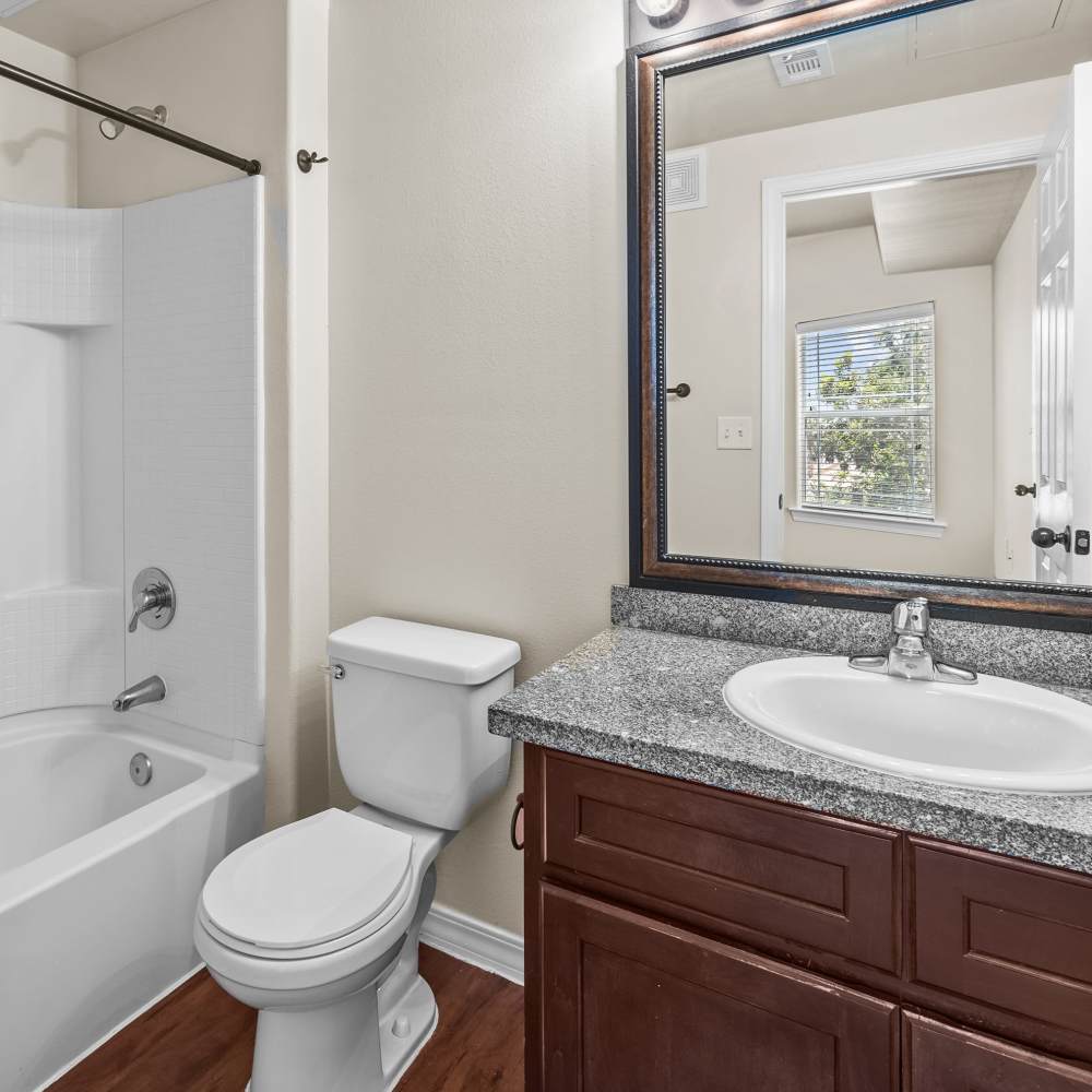 Bathroom with a toilet and a large mirror at Las Torres Apartments in El Paso, Texas