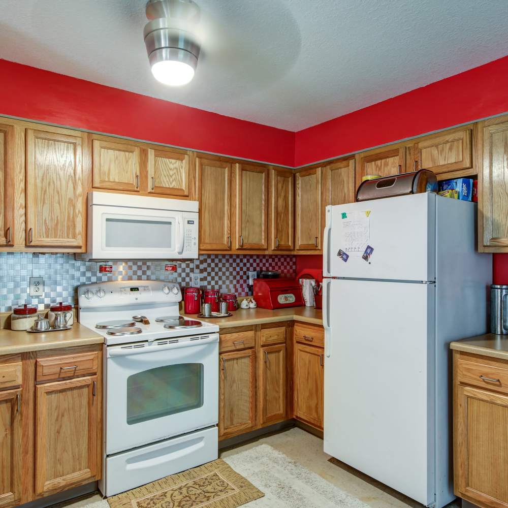 A kitchen with white appliances and wooden cabinetry at Oak Hollow in Summerville, South Carolina