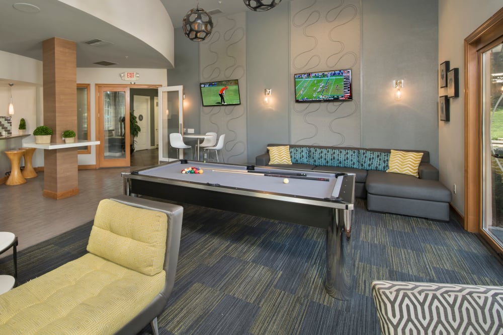Interior view of the resident clubhouse with a billiards table at Esplanade Apartment Homes in Riverside, California