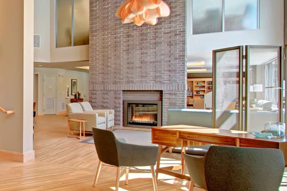 Bright, high-ceilinged common area with fireplace at Merrill Gardens at Ballard in Seattle, Washington