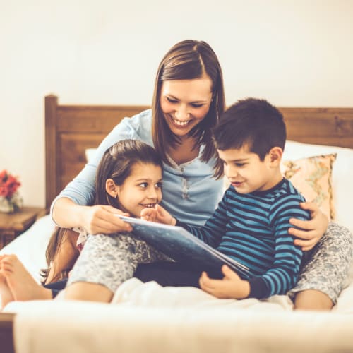 A happy mother with her kids reading story at Bonita Bluffs in San Diego, California