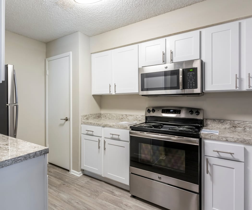 Modern kitchen with stainless-steel appliances and hardwood floors in model home at IMT Newport Colony in Casselberry, Florida