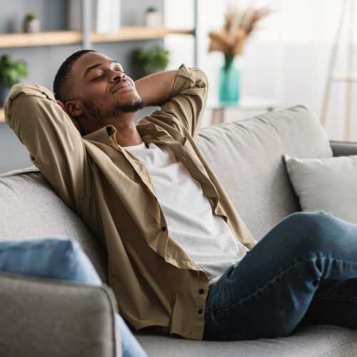 Man relaxing on sofa in modern living room at A.L. Miller Village in Macon, Georgia