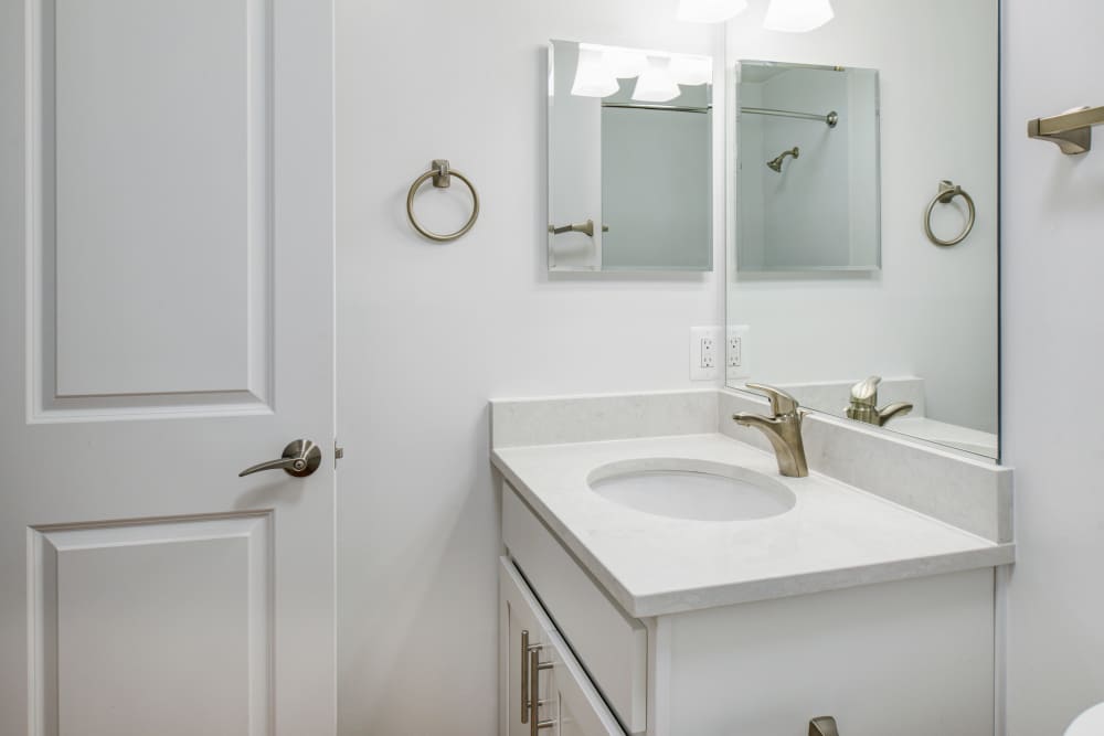 White cabinets and and a bathtub in an apartment bathroom at Stonecreek Club in Germantown, Maryland