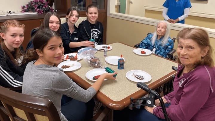 Willowbrook Place Memory Care residents and local students celebrate the holidays in Littleton Colorado