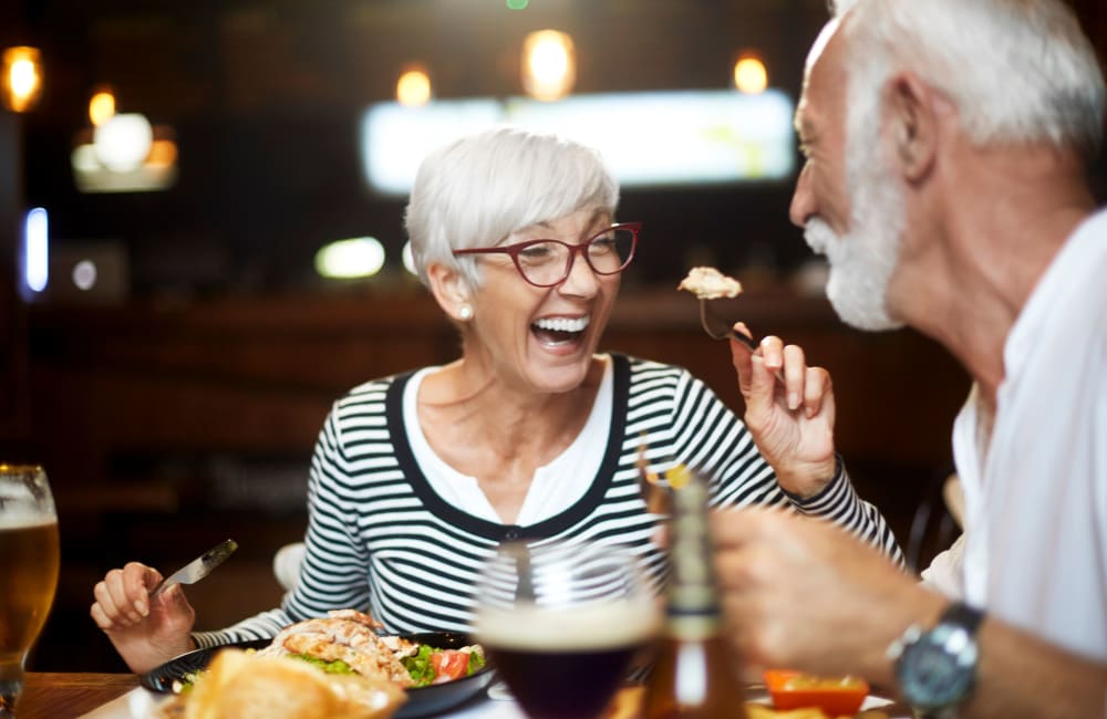 Couple chatting over dinner at Roseville Commons Senior Living in Roseville, California