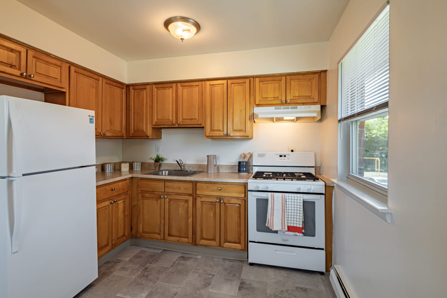 Kitchen with maple cabinets and white appliances Glen Ellen Apartment Homes in Long Branch, New Jersey