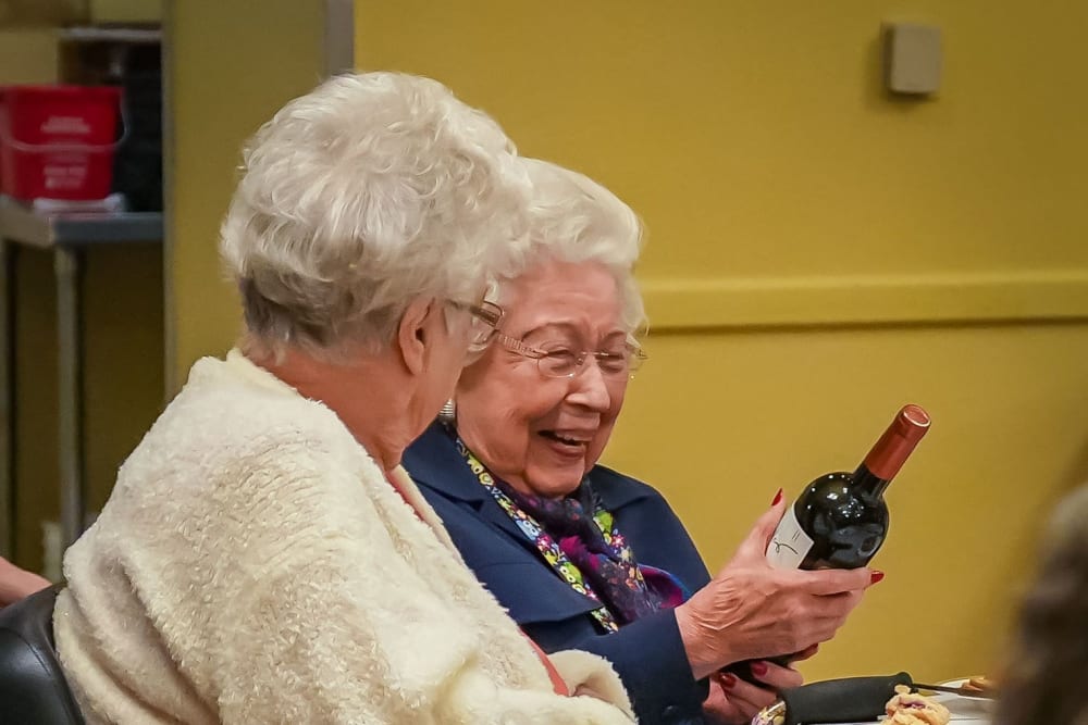Resident holding a bottle of wine as a gift at Winding Commons Senior Living in Carmichael, California