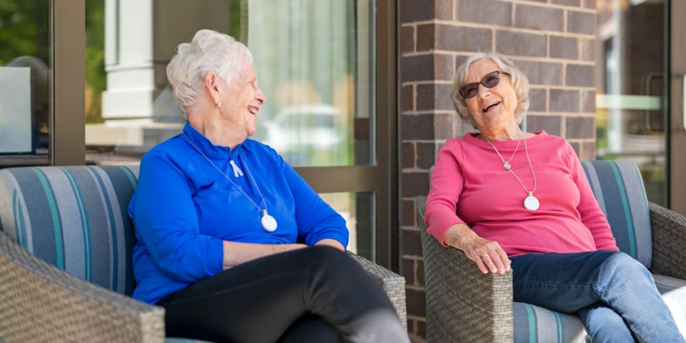 Resident and friend sitting outdoors at Anthology of Meridian Hills in Indianapolis, Indiana